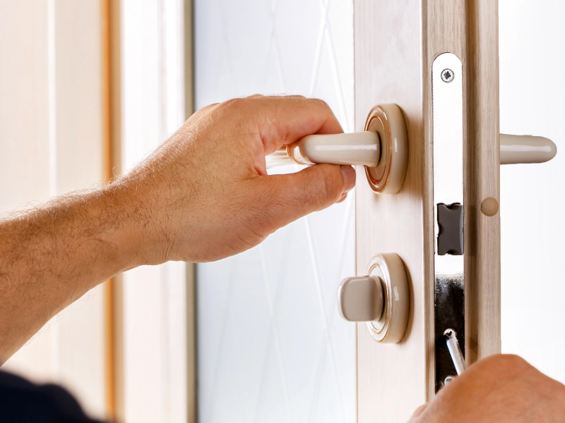 A locksmith changing out the pins inside a residential door lock