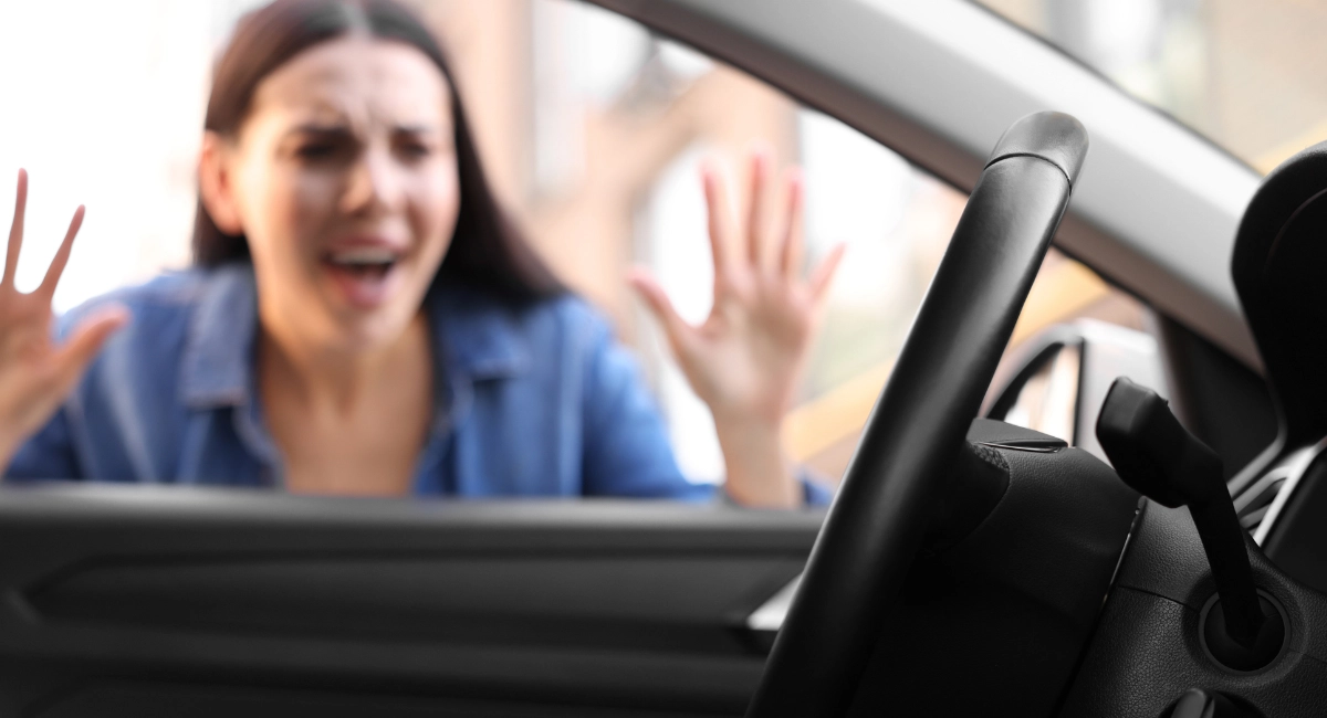 A woman frantically looking into her car