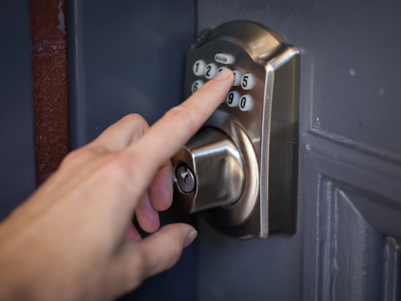 A person entering a code on a modern keypad deadbolt